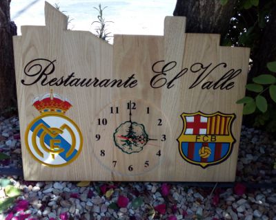 Cartel de empresa con reloj y dos escudos deportivos